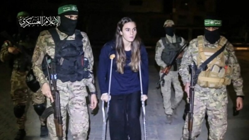 Auch diese junge Frau - am Bild von Hamas-Terroristen bewacht - kam frei. Sie wurde in ein israelisches Spital gebracht. (Bild: AFP)