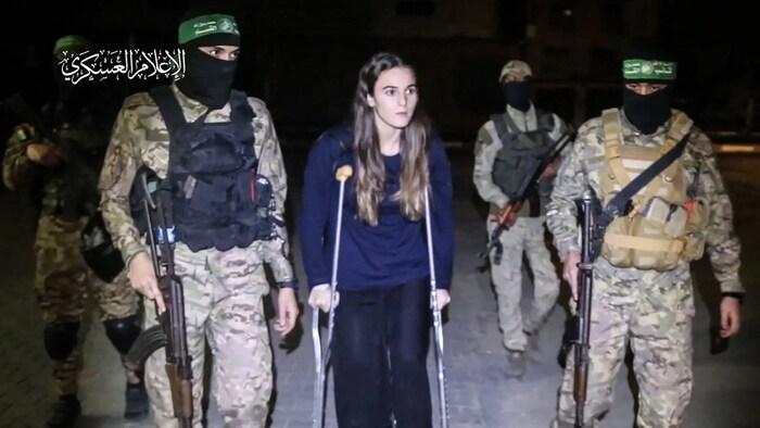 Auch diese junge Frau - am Bild von Hamas-Terroristen bewacht - kam frei. Sie wurde in ein ...