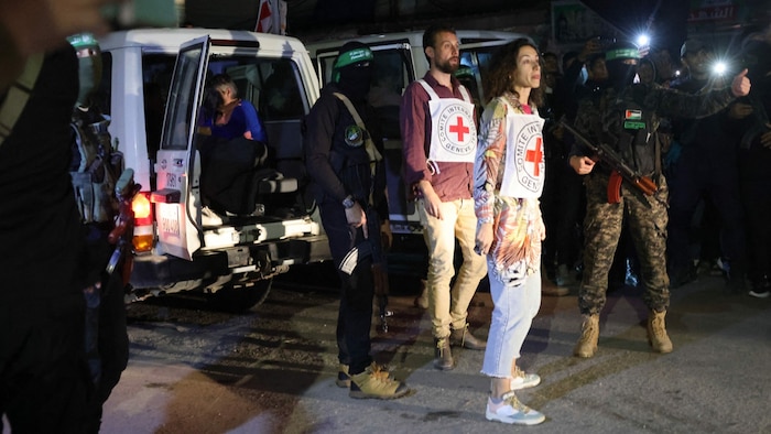 Mitglieder des Roten Kreuzes warten auf den Empfang der von der Hamas freigelassenen Geiseln in ...