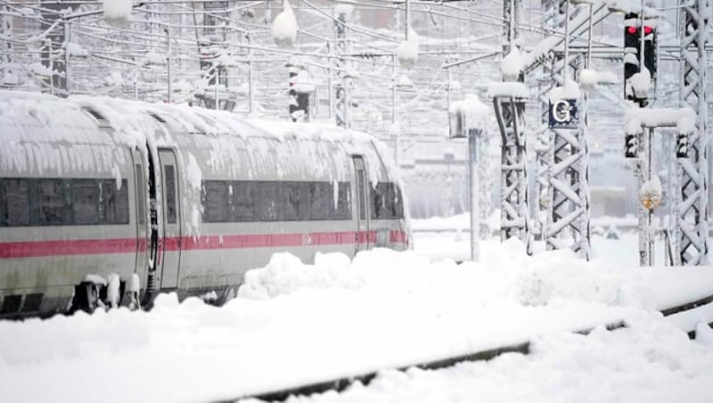 Eine eingeschneite Zuggarnitur in München (Bild: AP)