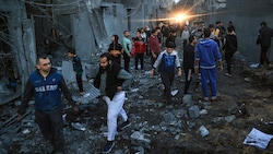 Palästinenser überprüfen die Schäden nach einem israelischen Angriff in Rafah im südlichen Gazastreifen am Sonntag. (Bild: AFP)