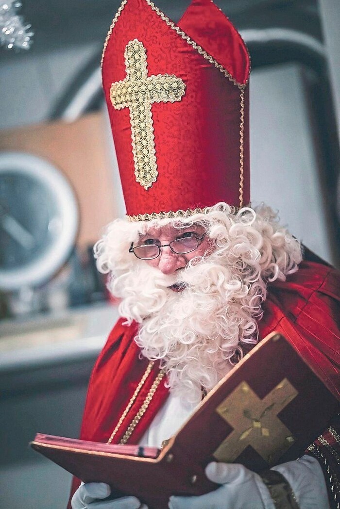 Der Nikolaus liest aus seinem goldenen Buch vor.