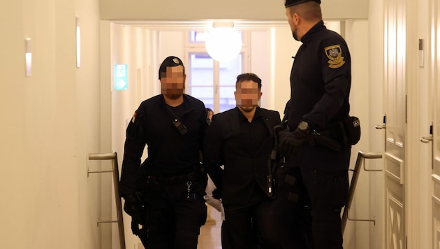 Der Angeklagte (26) wird von Justizwachbeamten in den Verhandlungssaal gebracht. (Bild: Tröster Andreas, Krone KREATIV)