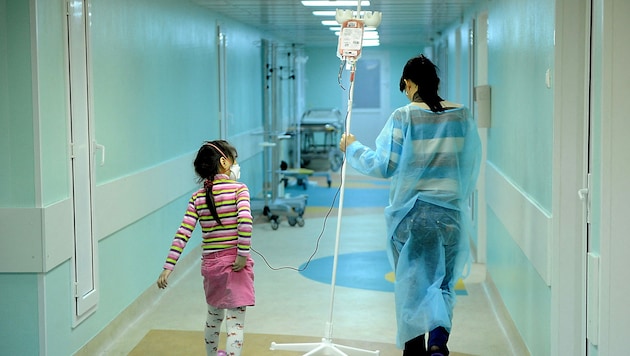 A girl with cancer and her mother (Bild: AFP)