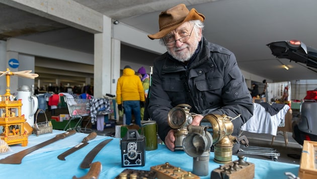 Der 74-jährige Reinhard Rath hält ein altes Fahrradlicht in seinen Händen. „Der Flohmarkt ist meine Leidenschaft.“ (Bild: Berger Susi)