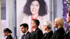 Im Hintergrund ist Narges Mohammadi zu sehen, im Vordergrund links ihre Kinder Kiana und Ali. (Bild: AFP)