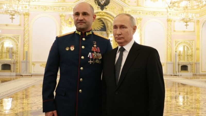 Putin (re.) mit dem Batallionsführer Artem Schoga, an dessen Brust ganz oben sein neuer Orden prangt. (Bild: APA/AFP/POOL/Mikhail Klimentyev)