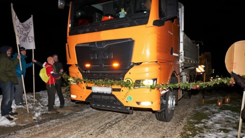 Der frühen Stunde zum Trotz stellte sich eine Handvoll engagierter Naturschützer mit einer symbolischen Blumenkette dem anrollendem Schwerverkehr im Jaidhaustal entgegen. (Bild: Eduard Hatzenbichler)