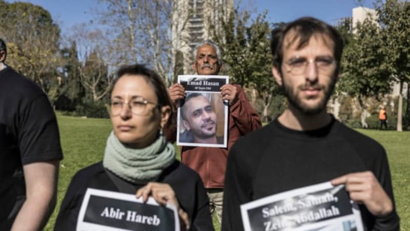 Aktivistinnen und Aktivisten in Israel erinnern mit Fotos an die getöteten Zivilpersonen im Gazastreifen. (Bild: AFP)