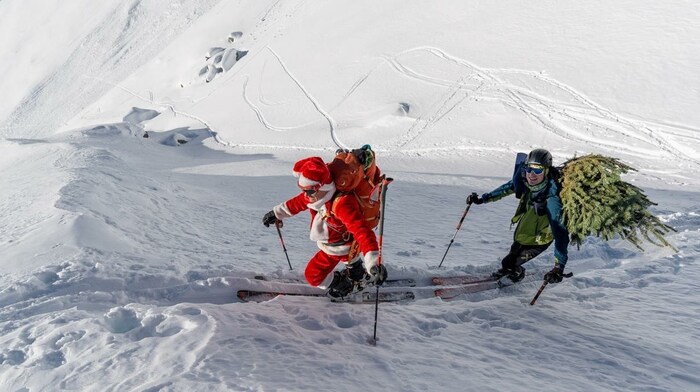 Florian Miller (re.) hat sich den Christbaum auf seinen Rucksack geschnallt.