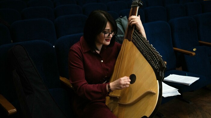 Die Frau spielt auf einer Bandura, einem gezupften Lauteninstrument in der Ukraine.