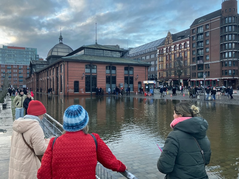 Hamburg: Zahlreiche Passanten und Spaziergänger sehen sich den leicht unter Wasser stehenden Fischmarkt an. (Bild: APA/dpa/Thomas Mller)