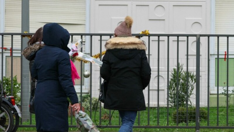 Nachbarinnen und Nachbarn legten vor der Wohnung der Familie Blumen ab. (Bild: AFP)