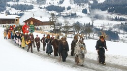 Begleitet von Musikanten ziehen die Schiach- und Schönperchten durch das verschneite Goldegg. (Bild: Gerhard Schiel)