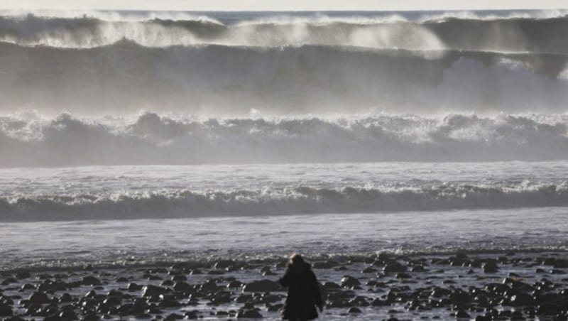 Eine Person spaziert am Strand im Bezirk Ventura County, als sich riesige Wellen nähern. (Bild: APA/Getty Images via AFP/GETTY IMAGES/MARIO TAMA)