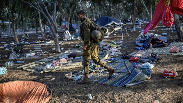 Ein israelischer Soldat patrouilliert nach dem Massaker am Ort des Geschehens. (Bild: APA/AFP/Aris MESSINIS)