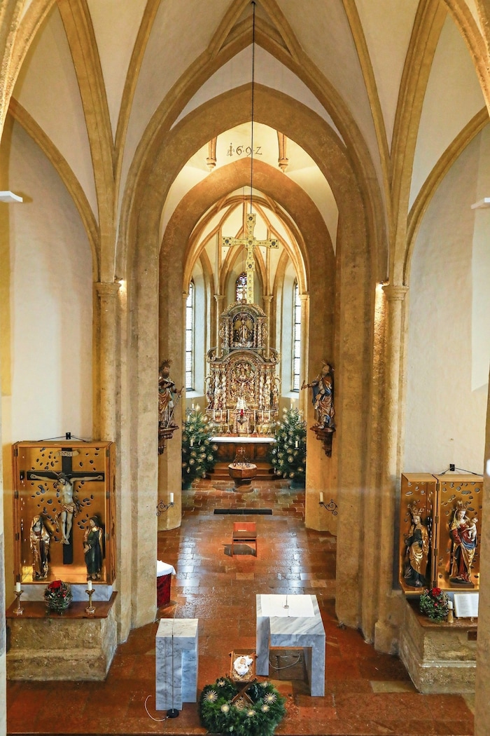 Hoch über den beiden modernen Altären in der Pfarrkirche ist eine Kopie des Rupertuskreuzes zu ...