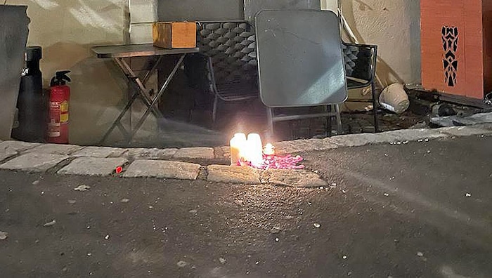 Vor der abgesperrten Lokaltür wurden Kerzen für die Opfer des Brandes aufgestellt.