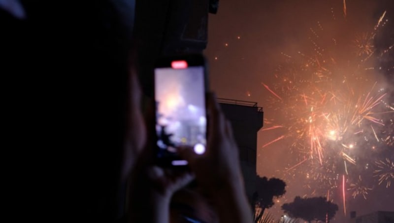 Eine Frau filmt das Feuerwerk zu Silvester in Neapel. (Bild: AFP/Eliano Imperato)