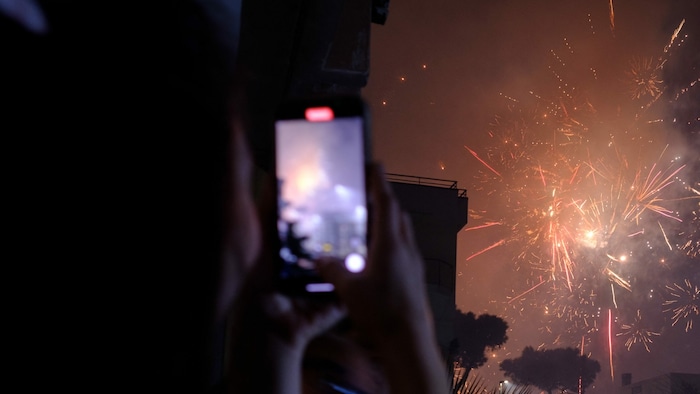Eine Frau filmt das Feuerwerk zu Silvester in Neapel.