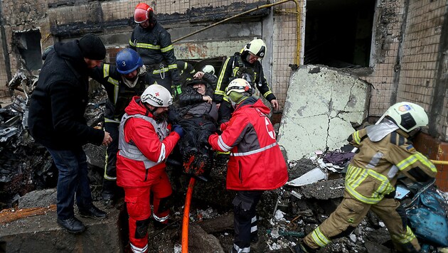 Rettungsarbeiten nach einem Raketenangriff auf Kiew: Obwohl westliche Geheimdienste einen Engpass kommen sahen, gehen Russland die Raketen nicht aus. (Bild: APA/AFP/Anatolii STEPANOV)