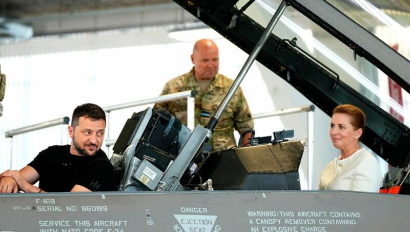 Der ukrainische Präsident Wolodymyr Selenskyj gemeinsam mit der dänischen Regierungschefing Mette Frederiksen beim Probesitzen in einem F-16-Cockpit (Bild: APA/AFP/Ritzau Scanpix/Mads Claus Rasmussen)