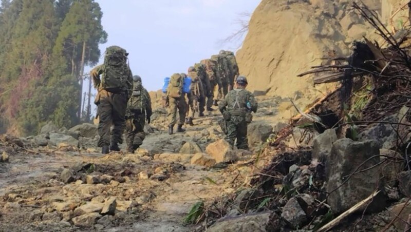 Mitglieder der Japan Self-Defense Forces bringen Nahrungsmittel und Medizin zu den noch von der Außenwelt abgeschnittenen Menschen. (Bild: Japanese Ministry of Defense/AP)