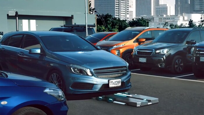 Ein „Parkie“ rollt unters Auto, um es in eine Parklücke zu bugsieren.