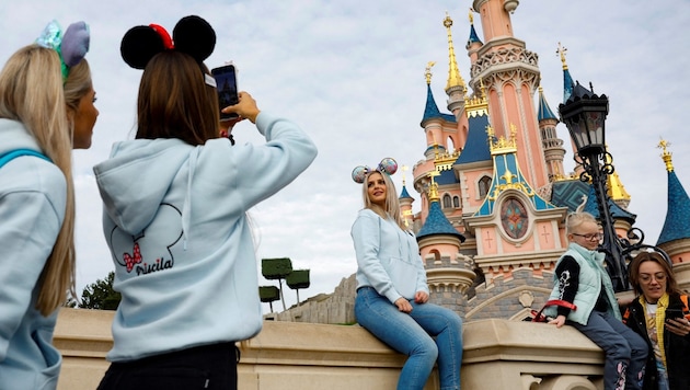 Normalerweise nehmen Touristen höchstens ihre Handys mit nach Disneyland ... (Bild: AFP)