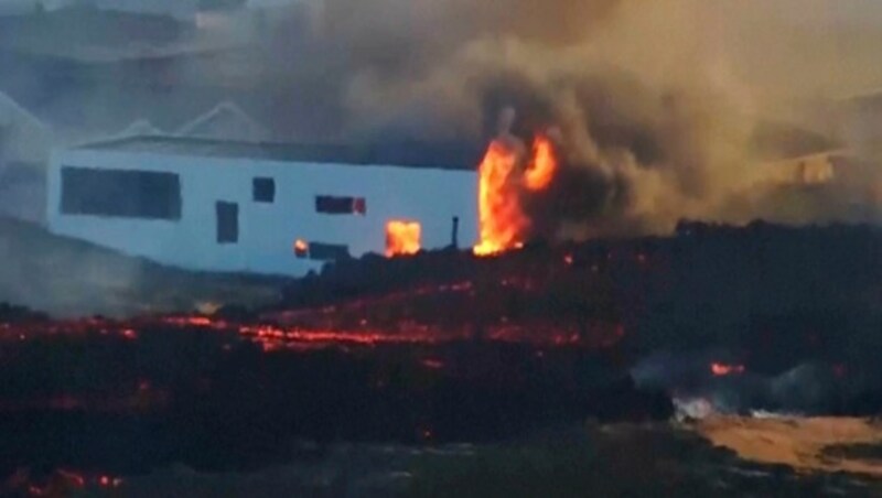 Die aus der Erde sprudelnde Lava erreichte erstmals auch den evakuierten Küstenort Grindavík, wo sie mehrere Häuser in Brand setzte. (Bild: Associated Press)