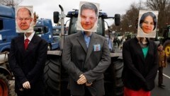 Ein mit Attrappen geschmückter Traktor mit Bildern von Bundeskanzler Olaf Scholz, Wirtschaftsminister Robert Habeck und Außenministerin Annalena Baerbock während der Bauern-Demo in Berlin am Montag. (Bild: AFP)