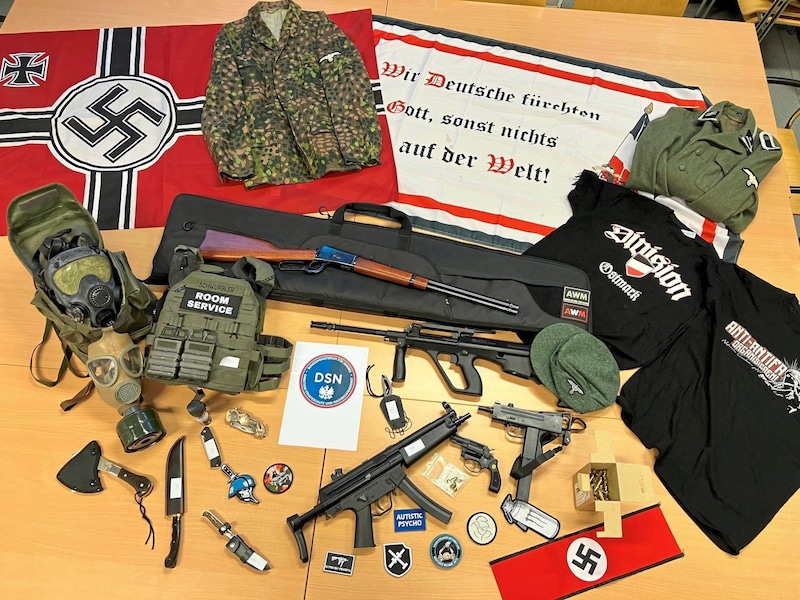 A 20 éves férfi lefoglalt terrorarzenálja: Fegyverek, gázálarcok, náci áhítati tárgyak. (Bild: DSN)