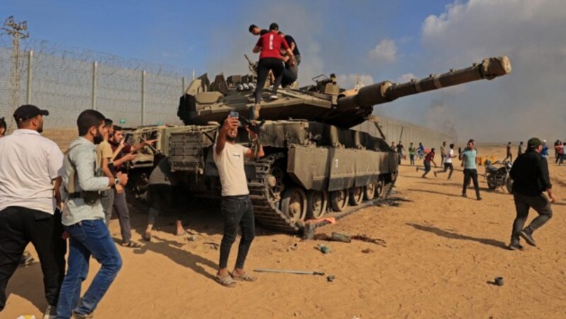 Palästinenser jubeln am 7. Oktober 2023 über einen von der israelischen Armee gekaperten Panzer. (Bild: APA/AFP/SAID KHATIB)