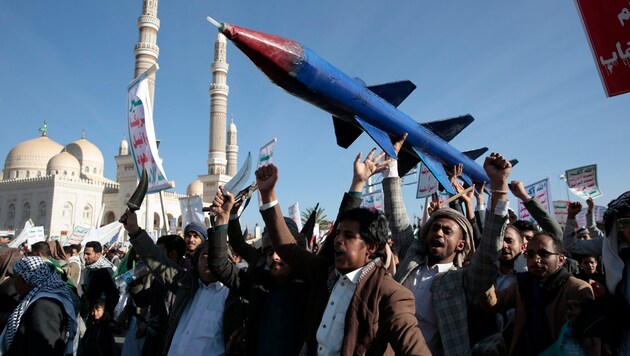 Příznivci Hútíů demonstrují s atrapou rakety v Jemenu. (Bild: AP)