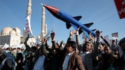 Houthi-Anhänger demonstrieren mit einer Raketen-Attrappe im Jemen. (Bild: AP)