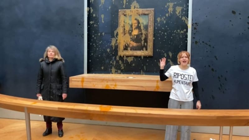 Zwei Aktivistinnen überschütteten am Sonntag die Mona Lisa im Louvre mit Suppe. (Bild: APA/AFP/AFPTV/David CANTINIAUX)