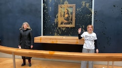 Zwei Aktivistinnen überschütteten am Sonntag die Mona Lisa im Louvre mit Suppe. (Bild: APA/AFP/AFPTV/David CANTINIAUX)