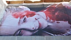 Krieg oder häusliche Gewalt: Ein blutverschmiertes Kind über dem Theater-Eingang in Gmunden (Bild: Wolfgang Spitzbart)