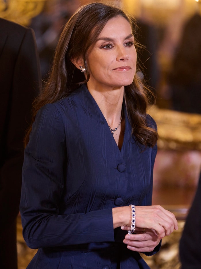 Königin Letizia legt sich ihr zuvor heruntergefallenes Armband wieder an.