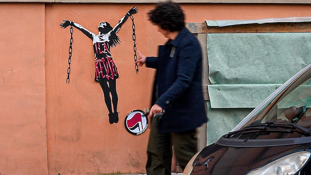 Graffiti autorstwa Ilarii Salis i jej łańcuchy na fasadzie budynku w pobliżu ambasady Węgier w Rzymie (Bild: AP)