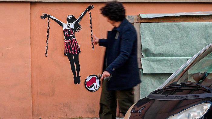 Ein Graffiti von Ilaria Salis und ihren Ketten an einer Hausfassade nahe der ungarischen Botschaft in Rom