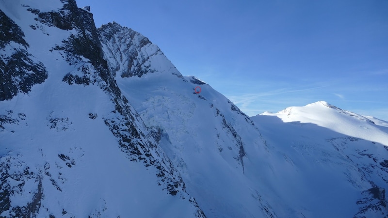 Inmitten des schneebedeckten Felsmassivs steht das Biwak - am Foto durch den roten Kreis markiert. (Bild: LPD Kärnten)