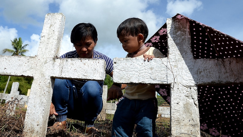 Angehörige von „Haiyan“-Opfern auf einem Friedhof auf den Philippinen (Bild: APA/AFP/Ted ALJIBE)