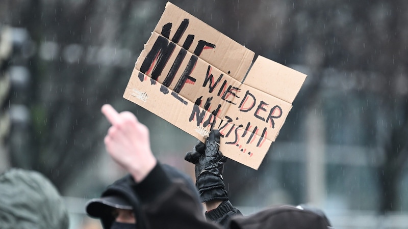 Gegendemonstranten laufen am Rande eines Aufmarschs von Rechtsextremen vor dem Hauptbahnhof entlang. (Bild: APA/dpa/Robert Michael)