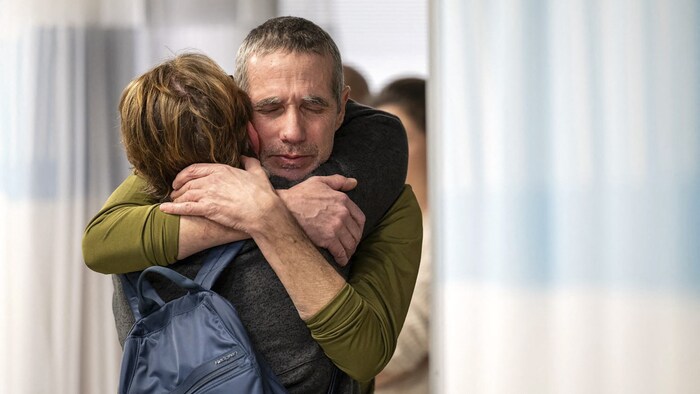 Fernando Simon Marman is hugged by a relative in hospital.