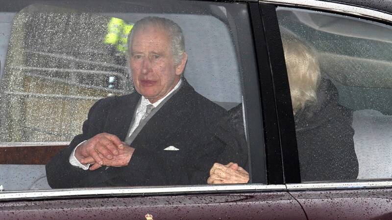 König Charles und Königin Camilla am Rücksitz ihrer Limousine. (Bild: APA/Jordan Pettitt/PA via AP)