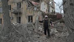 Eine Zivilistin auf Trümmern in Donezk (Bild: APA/AFP/Genya SAVILOV)