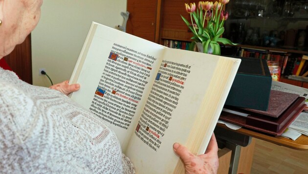 Frau N. mit einem der Faksimile-Bücher, als wir sie 2022 zu Hause besucht haben. Heute lebt die 80-Jährige im Seniorenheim und muss sich mit der Klage der Bank aus Deutschland herumärgern. (Bild: Klemens Groh)