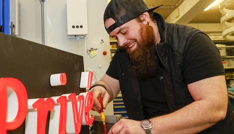 In der Elektrotechnik-Werkstatt geht es um Fingerspitzengefühl: Mitarbeiter Daniel Holzer arbeitet an einer Leuchtschrift. (Bild: Tschepp Markus)