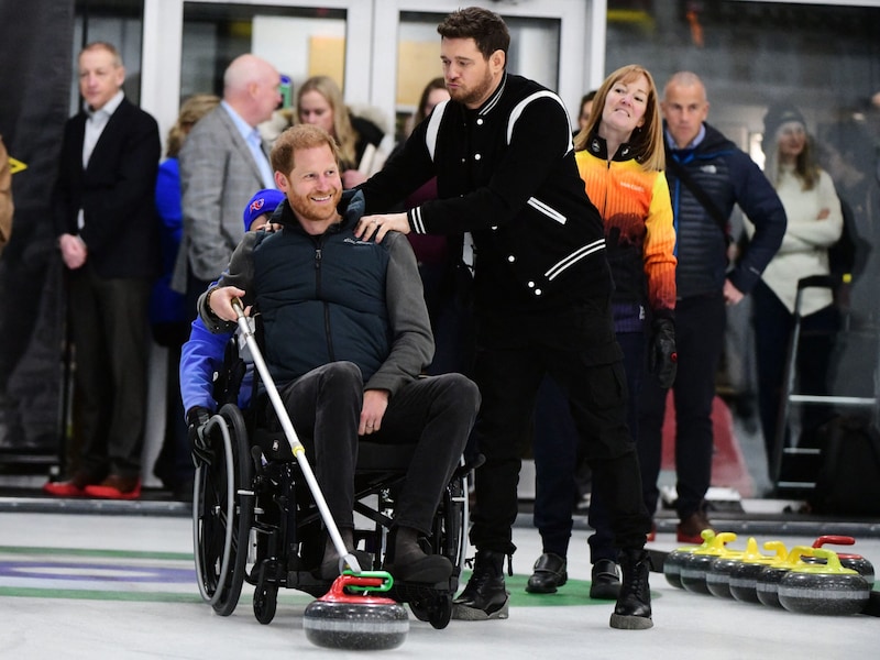 Prinz Harry und Michael Bublé hatten sichtlich Spaß beim Rollstuhl-Curling. (Bild: APA/AFP/Don MacKinnon)